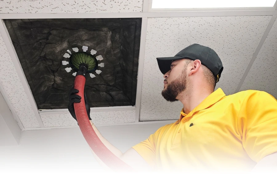 Technician Cleaning Ceiling Air Duct with Rotary Brush – "Air duct cleaning professional using a rotary brush system to thoroughly clean a ceiling vent, ensuring improved airflow and indoor air quality in NJ."