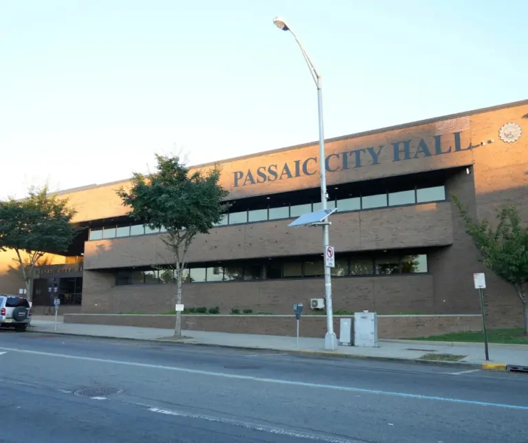 Exterior view of Passaic City Hall with a wide sidewalk and modern architecture, located in the heart of historic downtown Passaic, New Jersey.
